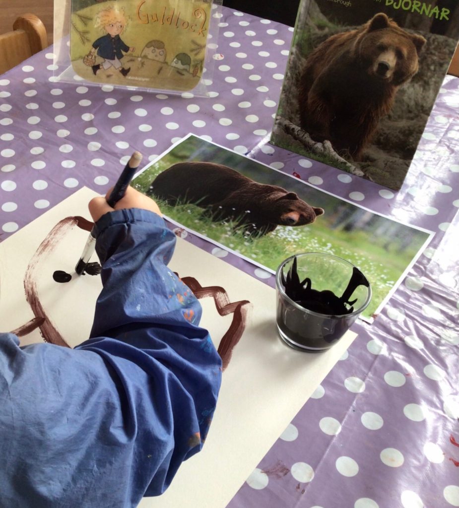 Barn tecknar av en bild på en brunbjörn