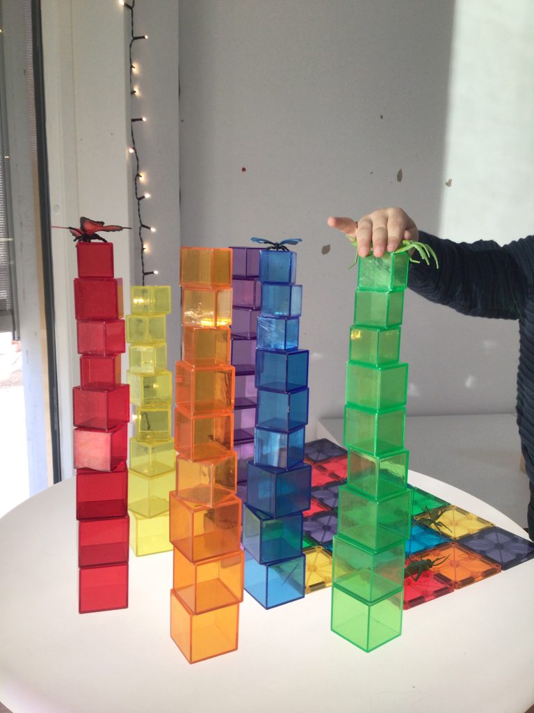 Barn bygger torn av färgglada kuber