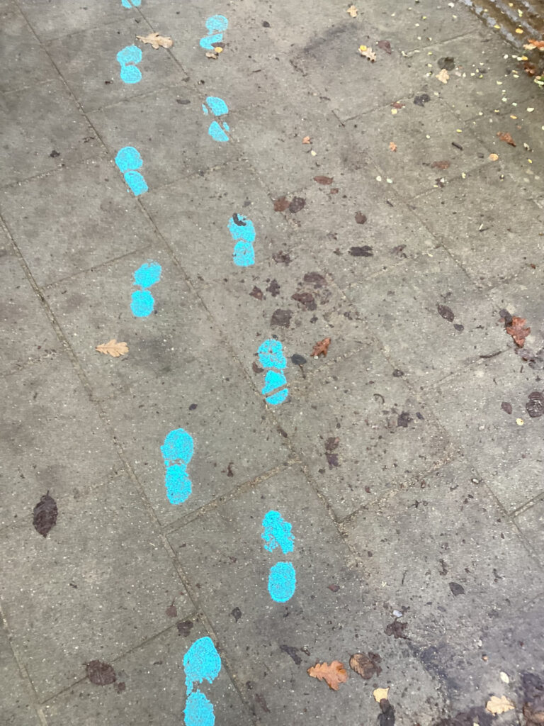 Fotspår av målarfärg avbildade på marken